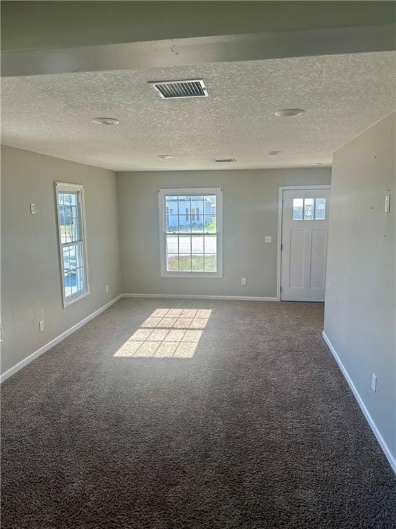 carpeted spare room with a textured ceiling