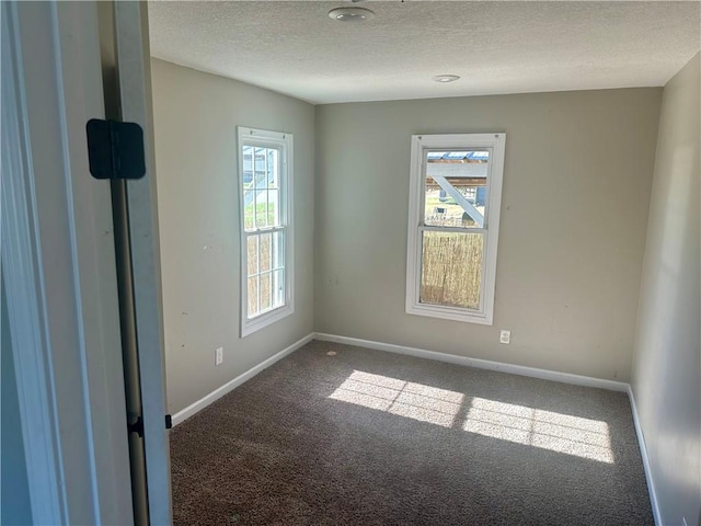 carpeted spare room featuring a textured ceiling