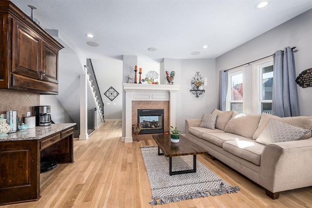 living room featuring light hardwood / wood-style floors and a tile fireplace