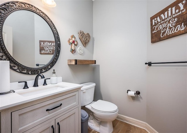 bathroom featuring wood-type flooring, toilet, and vanity