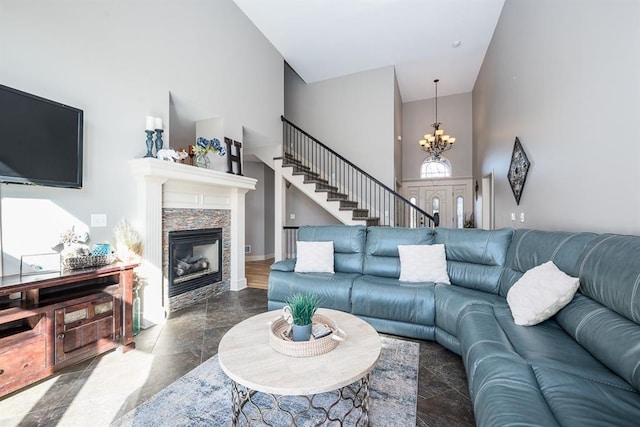 living room featuring high vaulted ceiling, an inviting chandelier, and a high end fireplace