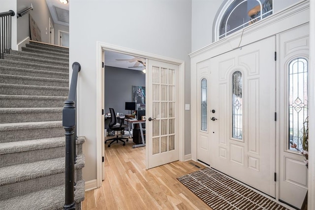 foyer with french doors, light hardwood / wood-style floors, ceiling fan, and a wealth of natural light