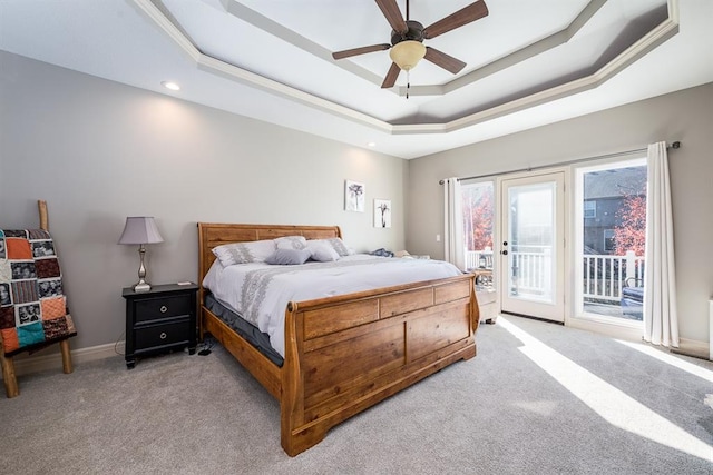 bedroom featuring access to outside, a tray ceiling, light colored carpet, and ceiling fan