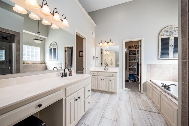 bathroom with high vaulted ceiling, vanity, tile patterned flooring, and a bathtub