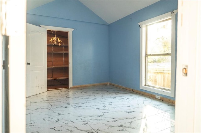 unfurnished room featuring vaulted ceiling