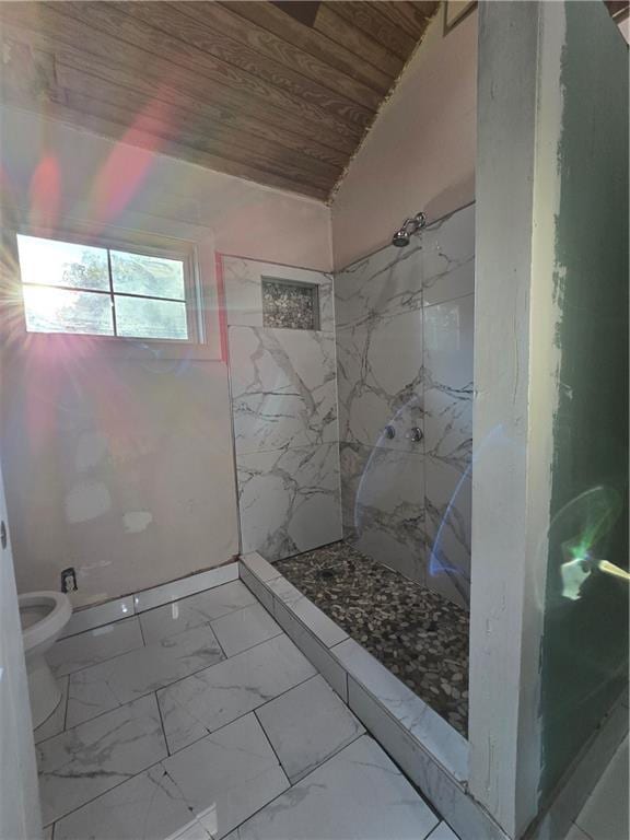 bathroom featuring toilet, a tile shower, and wood ceiling