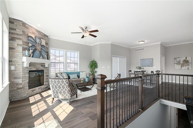 living room with a fireplace, ceiling fan, crown molding, and dark hardwood / wood-style flooring