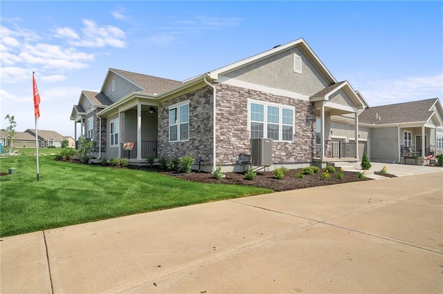 11901 S Tallgrass Dr Unit 702, Olathe, KS 66061 - view of side of home with covered porch, stone siding, a lawn, central air condition unit, and stucco siding