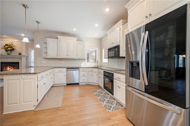 kitchen featuring black appliances, plenty of natural light, white cabinets, and kitchen peninsula