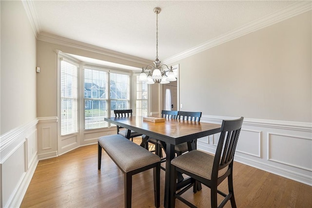 dining room featuring hardwood / wood-style flooring, crown molding, and an inviting chandelier