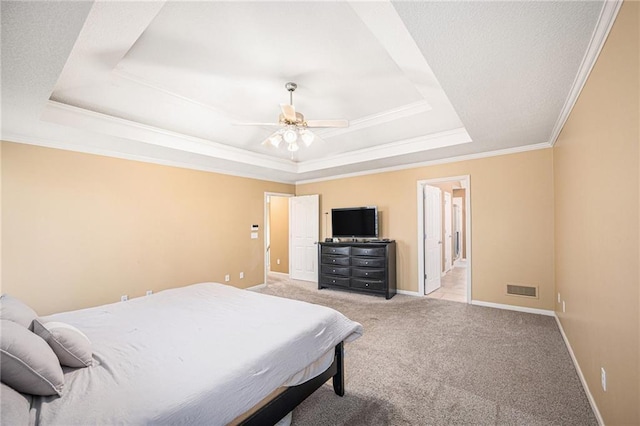 carpeted bedroom with ceiling fan, ensuite bath, crown molding, and a tray ceiling