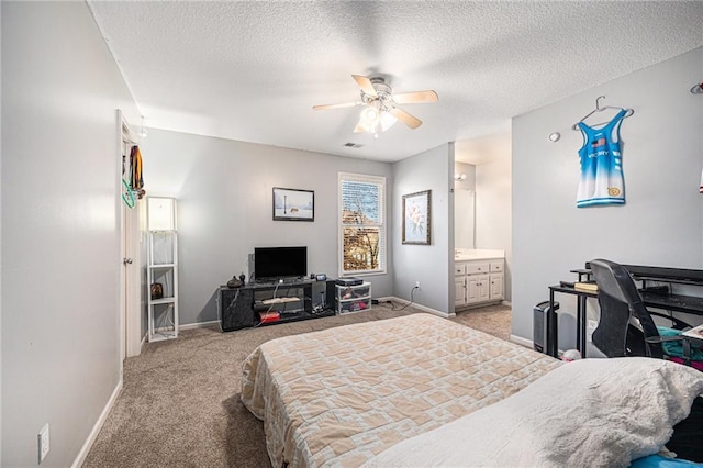 bedroom featuring ceiling fan, light colored carpet, a textured ceiling, and ensuite bath