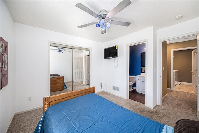 carpeted bedroom with ceiling fan, ensuite bath, and a closet