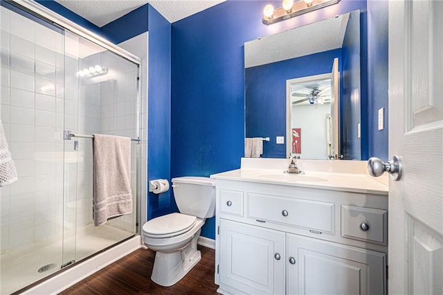 bathroom featuring an enclosed shower, toilet, a textured ceiling, vanity, and hardwood / wood-style flooring