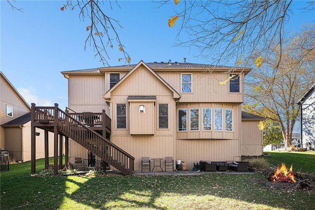 back of house with a lawn, a patio area, an outdoor living space with a fire pit, and a deck