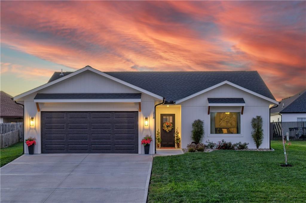 single story home featuring a yard and a garage