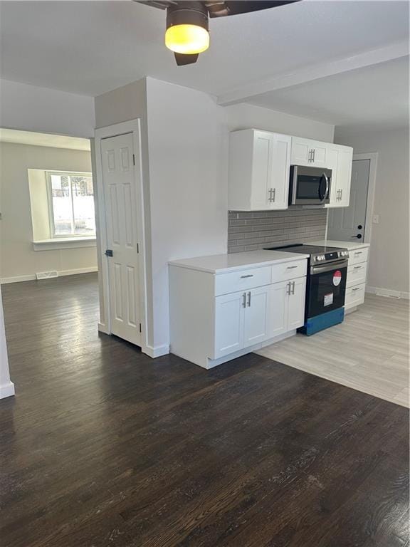 kitchen with white cabinets, decorative backsplash, dark hardwood / wood-style floors, and stainless steel appliances