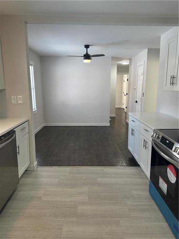 kitchen featuring stainless steel appliances, white cabinetry, and ceiling fan