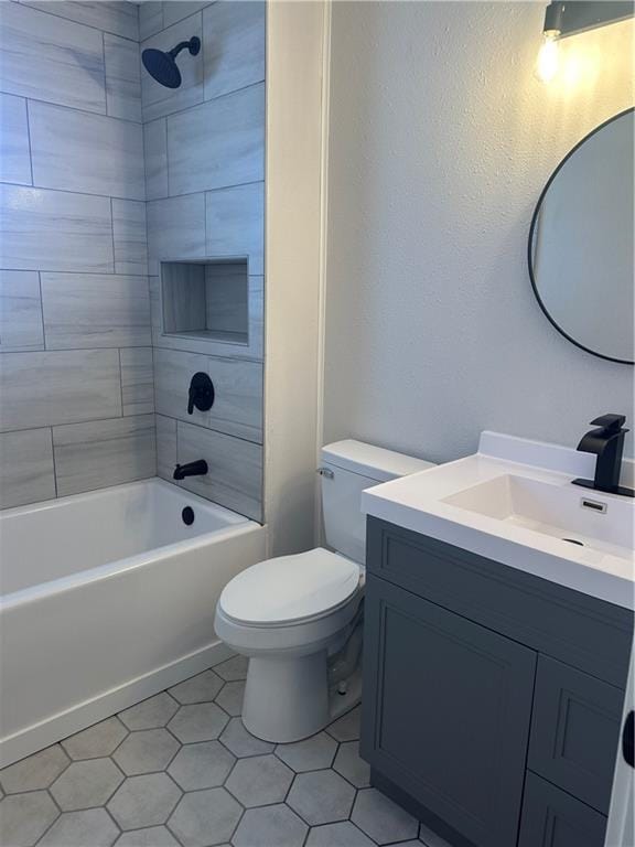 full bathroom featuring vanity, tile patterned floors, tiled shower / bath combo, and toilet