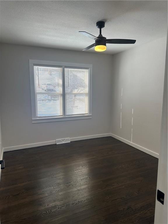 spare room featuring ceiling fan and dark hardwood / wood-style floors