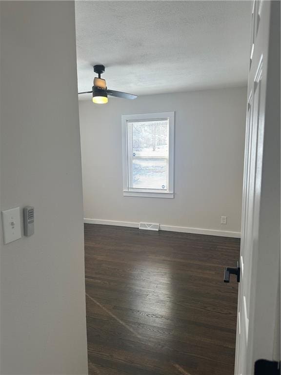 unfurnished room with dark wood-type flooring