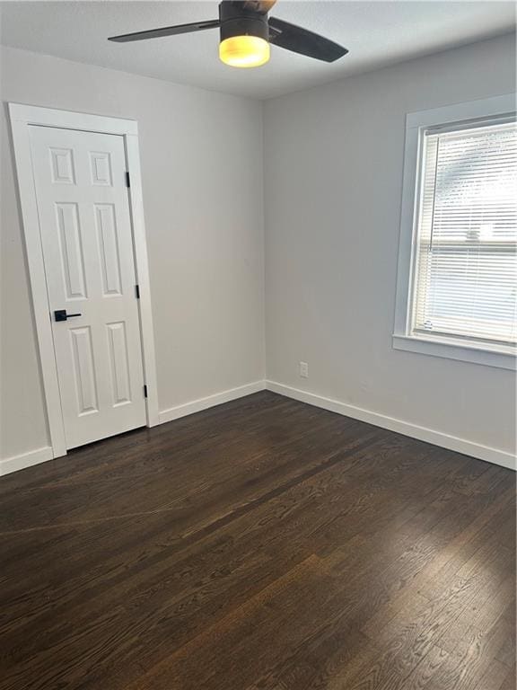 unfurnished room featuring ceiling fan and dark wood-type flooring