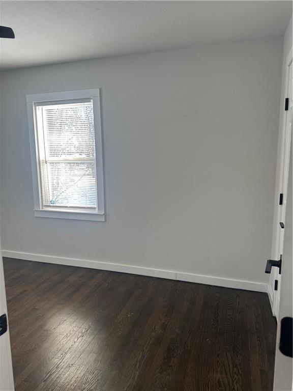 spare room with dark hardwood / wood-style flooring