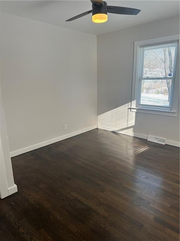 spare room with ceiling fan and dark wood-type flooring