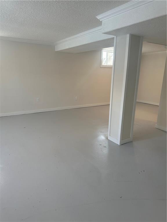 basement with a textured ceiling and ornamental molding