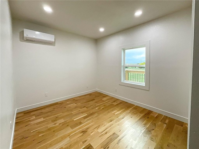 unfurnished room featuring light wood-type flooring and a wall mounted AC