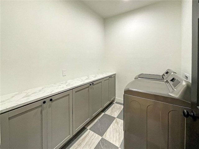 washroom featuring washer and clothes dryer and cabinets