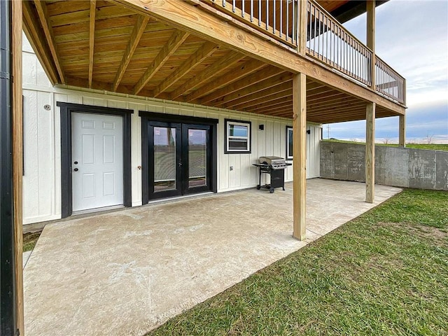 view of patio featuring a wooden deck, french doors, and grilling area