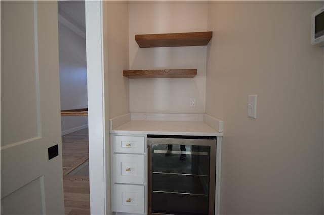 bar featuring beverage cooler and white cabinets