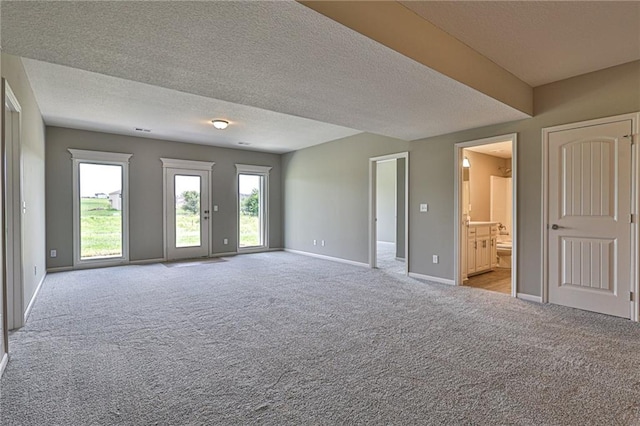 carpeted spare room featuring a textured ceiling