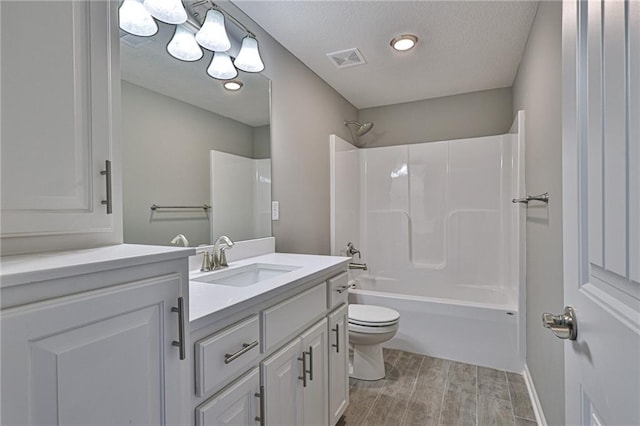 full bathroom featuring wood-type flooring, vanity, a textured ceiling,  shower combination, and toilet