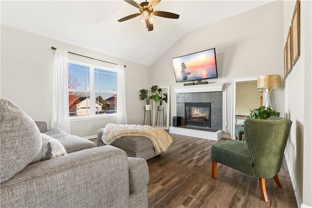 living room featuring a tiled fireplace, lofted ceiling, ceiling fan, and dark hardwood / wood-style floors