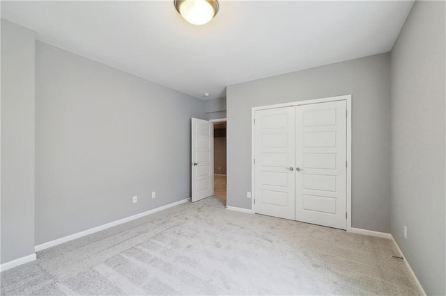 unfurnished bedroom featuring light carpet and a closet