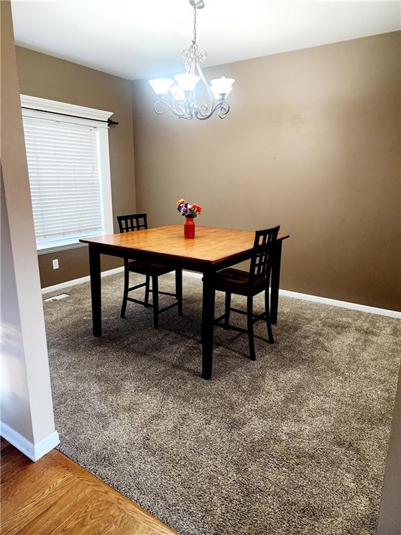 dining room featuring hardwood / wood-style floors and an inviting chandelier