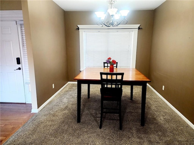 dining space with a notable chandelier and dark hardwood / wood-style flooring