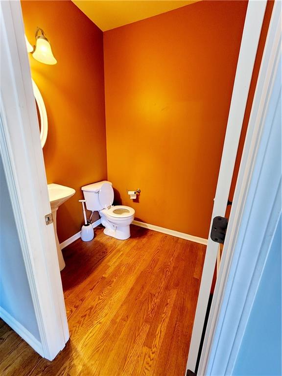 bathroom with toilet and hardwood / wood-style flooring