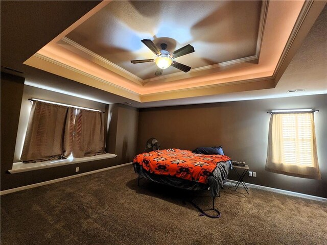 carpeted bedroom featuring ceiling fan, crown molding, and a tray ceiling