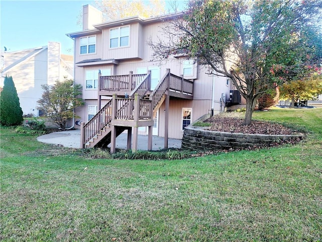 back of property with a patio area, a yard, and a wooden deck