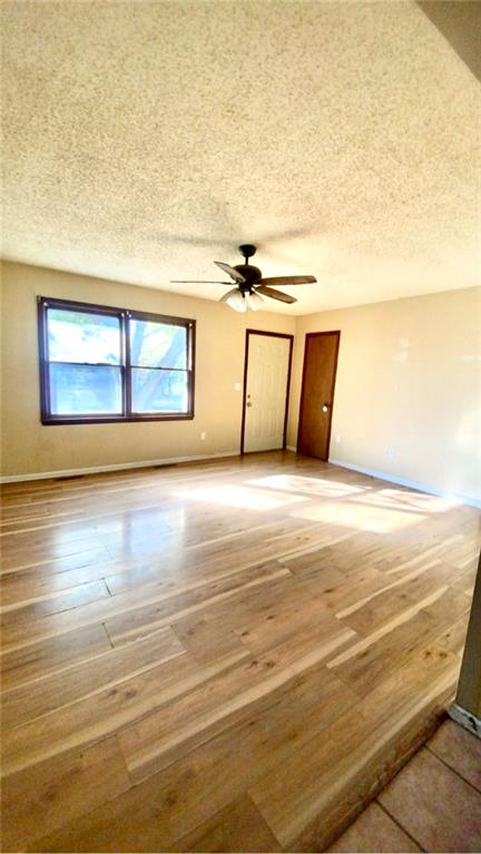 spare room featuring ceiling fan, hardwood / wood-style floors, and a textured ceiling