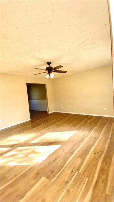 unfurnished room with a textured ceiling, hardwood / wood-style flooring, and ceiling fan