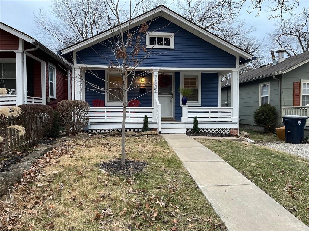 bungalow-style house featuring covered porch and a front lawn