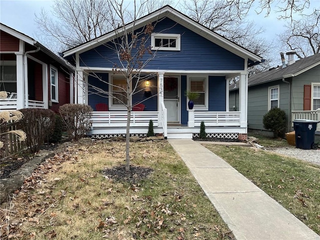 bungalow-style house featuring covered porch and a front lawn