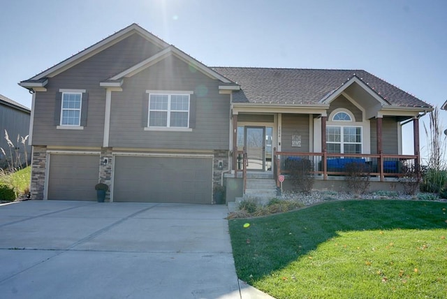 view of front of home with a porch, a garage, and a front lawn