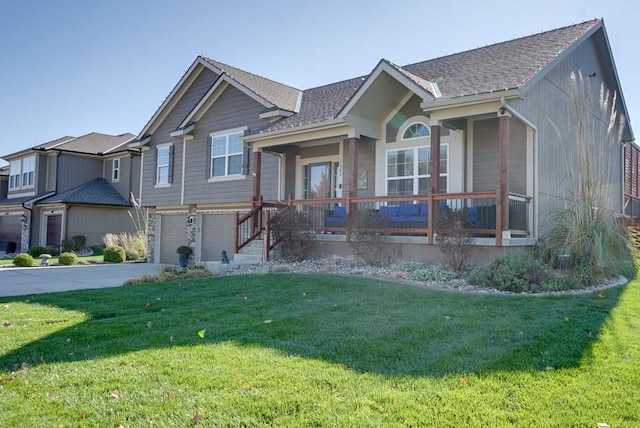 view of front facade with covered porch, a garage, and a front yard