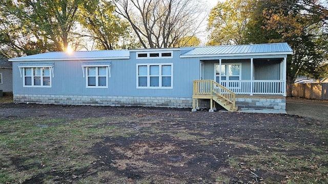 rear view of property featuring covered porch