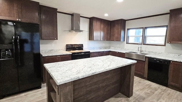 kitchen featuring ornamental molding, wall chimney range hood, sink, black appliances, and a center island